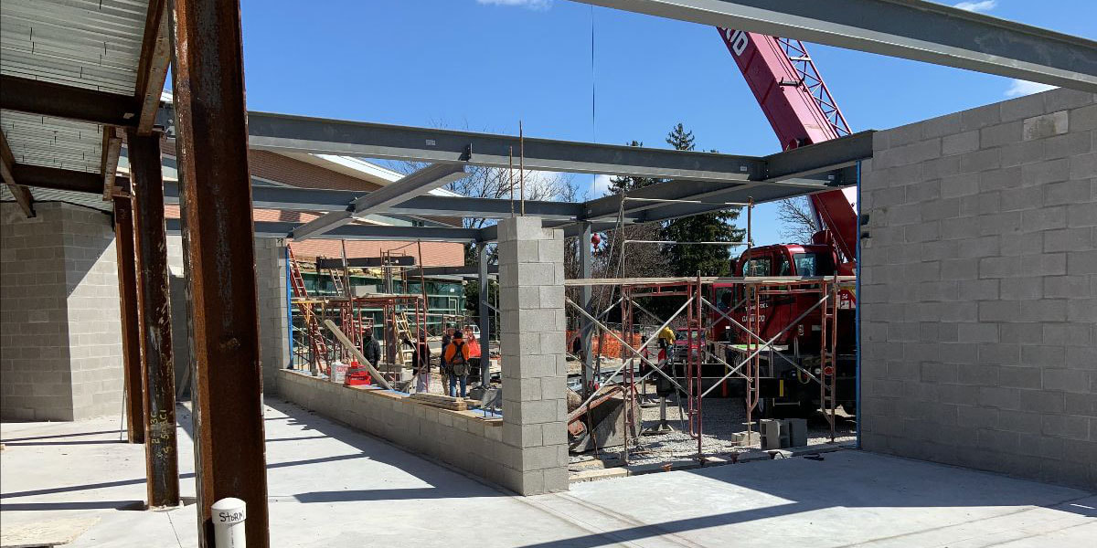 April 1, 2021, picture showing new walls and steel decking for the library addition, a drive-up window, workroom, new entryway, and covered walkway from the parking lot.