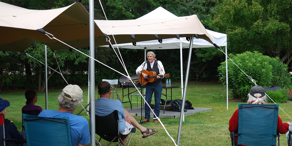 Picture of singer and guitarist Mark Dvorak performing on the library lawn