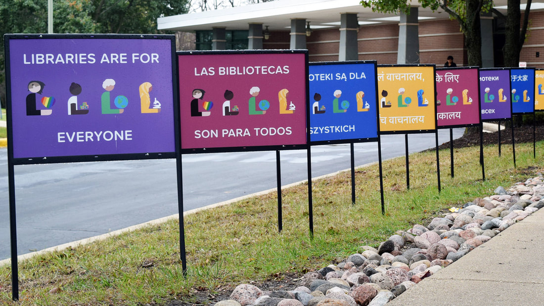 Row of signs in front of the library entrance that read 